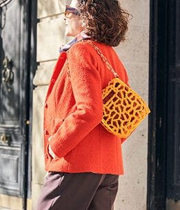 Mujer de 50 años llevando un look de entretiempo combinado con un bolso impreso en 3D modelo tubo vertice