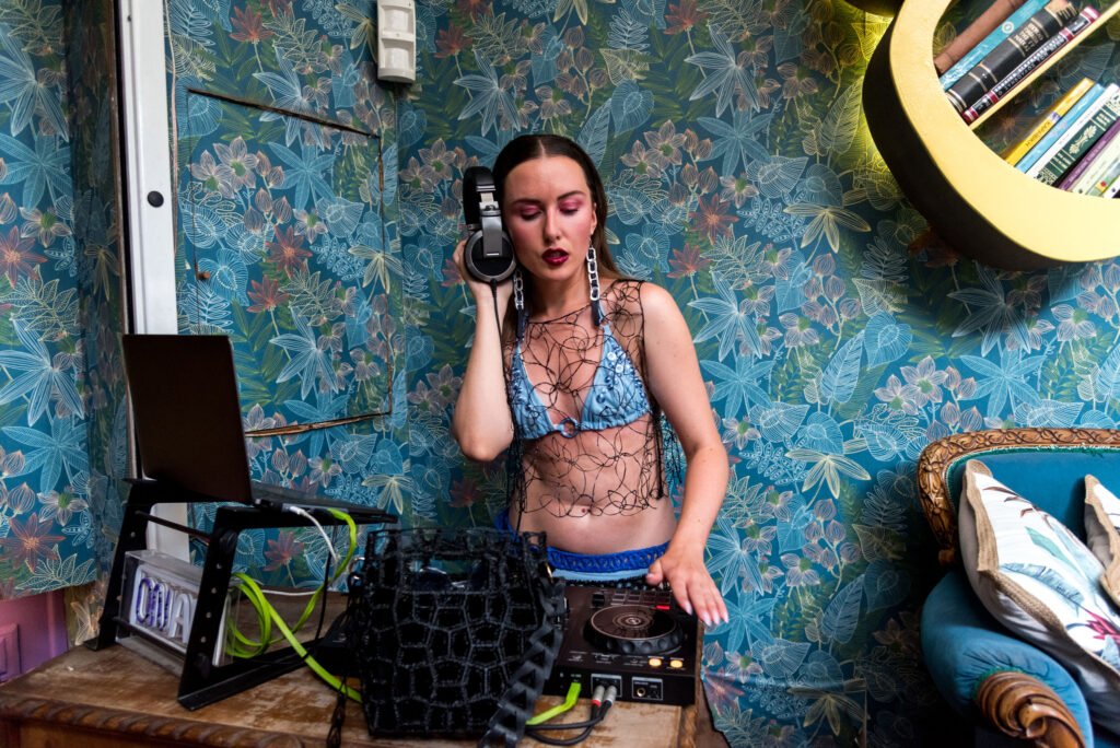 Modelo luciendo un look de nodos by g llevando el chaleco en 3D hecho a mano, bikini impreso en 3d en azul, set de cinturones 3d en azul y negro y el bolso tube classic negro.